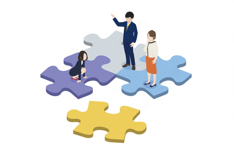 パズルの上に人が3人立っているイラスト