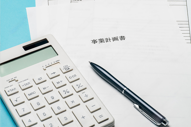 事業計画書と電卓の画像